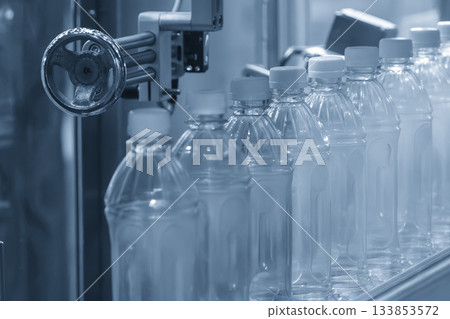 The  empty drinking water bottles  on the  conveyor belt for filling process in the blue scene. 133853572