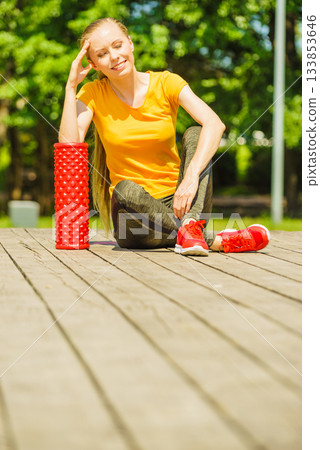 Girl doing exercises outdoor, using roller 133853646