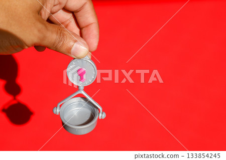 Weight scale in Hand at Red Background 133854245