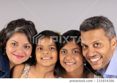A family of four, a man and three girls, are smiling for the camera 133854266