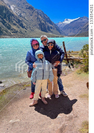 A family of four posing for a photo by a Llanganuco lagoon, Peru A family of four posing for a photo by a Llanganuco lagoon, Peru 133854281