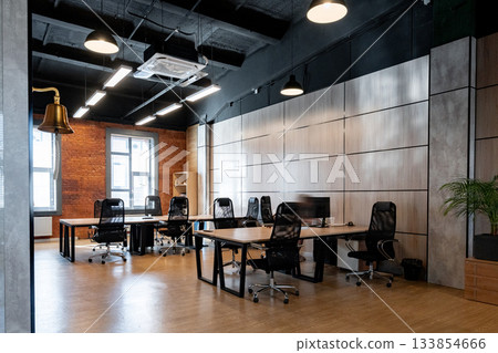 Modern office space with several workstations and natural light on a weekday Modern office space with several workstations and natural light on a weekday 133854666