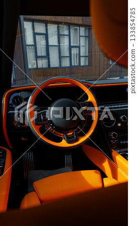 Luxury car interior featuring bold orange accents in a modern setting 133854785