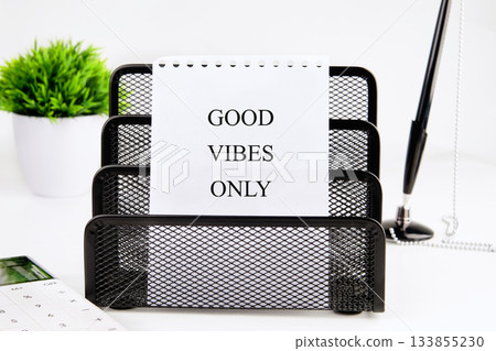 A stylish office desk is set with a note that says good vibes only in bold letters A stylish office desk is set with a note that says good vibes only in bold letters 133855230