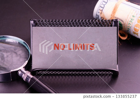 A bold message reading no limits stands out against a textured background, accompanied by a magnifying glass and a rolled banknote, symbolizing ambition and opportunity A bold message reading no limits stands out against a textured background, accompanied by a magnifying glass and a rolled banknote, symbolizing ambition and opportunity 133855237