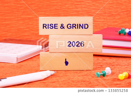 Bright orange setting highlights wooden blocks that bear the message rise and grind alongside the year 2026, symbolizing ambition and motivation for success in the upcoming future Bright orange setting highlights wooden blocks that bear the message rise and grind alongside the year 2026, symbolizing ambition and motivation for success in the upcoming future 133855258
