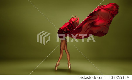Ballet dancer in red fabric sweep on olive green background in motion. Ballet dancer in red fabric sweep on olive green background in motion. 133855329