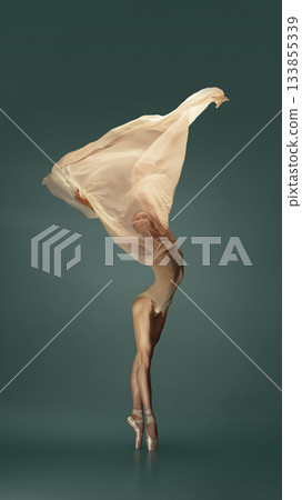 Ballet dancer on pointe wrapped in soft fabric wave on deep green background Ballet dancer on pointe wrapped in soft fabric wave on deep green background 133855339