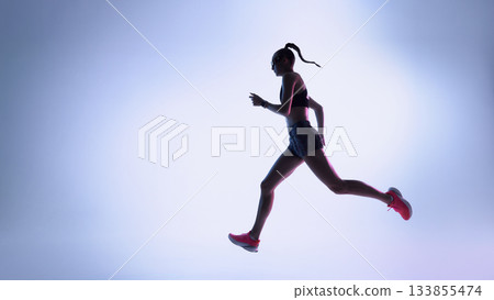 Futuristic female runner moving in dynamic silhouette across neon gradient background 133855474
