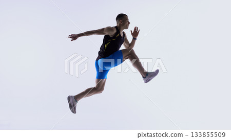 Athlete jumping forward in extended mid-stride. 133855509