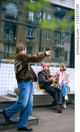 Friends talking outside cafe in winter street scene Friends talking outside cafe in winter street scene 133855588