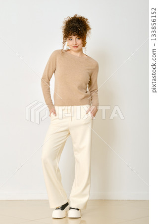 Model poses in stylish outfit for casual fashion shoot in a bright studio setting 133856152