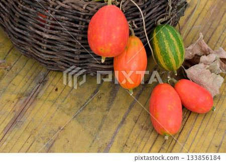 Red fruit of the vine jutting out of the basket Red fruit of the vine jutting out of the basket 133856184