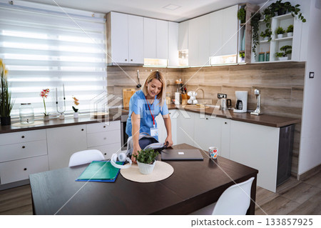 Female Doctor Preparing her Bag in the Kitchen Before Going to Work Female Doctor Preparing her Bag in the Kitchen Before Going to Work 133857925