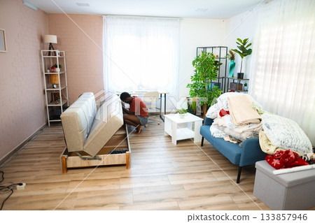 Young man assembling sofa in new apartment 133857946