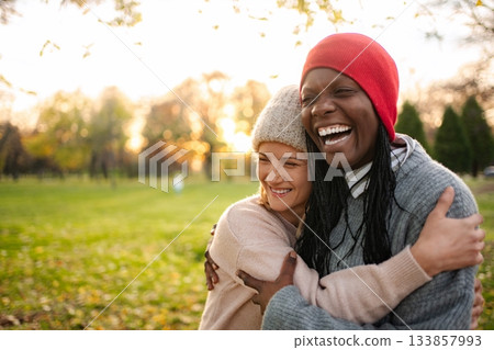 Diverse friends hugging and laughing in autumn park 133857993