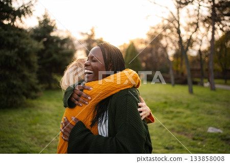 Happy diverse women embracing in park, showing friendship Happy diverse women embracing in park, showing friendship 133858008