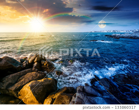 beautiful view of rocky sea coast under dramatic sky. day and night time change concept. scenic summer solstice landscape of beach under sun and moon at twilight. coastal background with large stones 133860317
