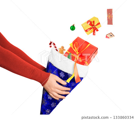 Hands holding a blue Christmas stocking while gifts and ornaments fall into it, isolated on a clean white background. High quality photo Hands holding a blue Christmas stocking while gifts and ornaments fall into it, isolated on a clean white background. High quality photo 133860334