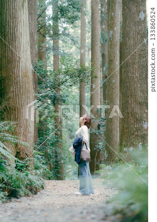 一位婦女在朝聖途中穿過雪松林 133860524