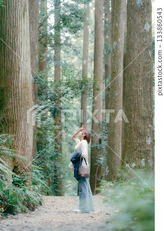 一位婦女在朝聖途中穿過雪松林 133860543