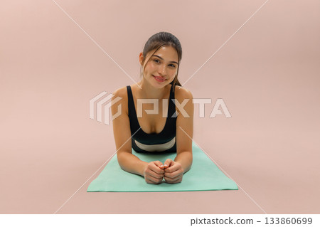 Young woman doing fitness plank on yoga mat in studio, wellness and workout training with yoga mat, healthy lifestyle and fitness routine, sport motivation and home workout concept. Young woman doing fitness plank on yoga mat in studio, wellness and workout training with yoga mat, healthy lifestyle and fitness routine, sport motivation and home workout concept. 133860699