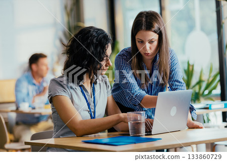 Two Female Startup Team Members Preparing Pitch Presentation Notes at Conference Venue Cafe Two Female Startup Team Members Preparing Pitch Presentation Notes at Conference Venue Cafe 133860729