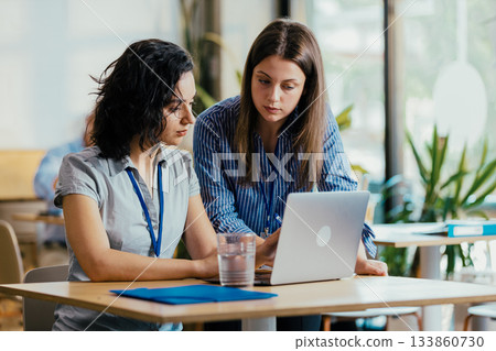 Two Female Startup Team Members Preparing Pitch Presentation Notes at Conference Venue Cafe Two Female Startup Team Members Preparing Pitch Presentation Notes at Conference Venue Cafe 133860730