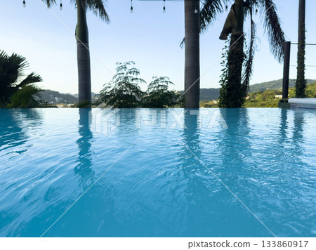 Relaxing infinity pool with scenic view over hills and trees Relaxing infinity pool with scenic view over hills and trees 133860917