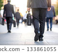 城市熙熙攘攘，人們沿著鵝卵石街道匆匆而過。 133861055