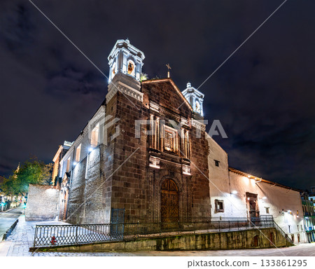Stone facade of El Carmen Bajo church glows under night sky in Quito, Ecuador. Historic colonial building features wooden doors and twin bell towers in UNESCO World Heritage center Stone facade of El Carmen Bajo church glows under night sky in Quito, Ecuador. Historic colonial building features wooden doors and twin bell towers in UNESCO World Heritage center 133861295