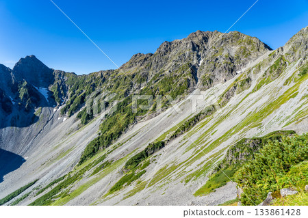 View of Mount Okuhotaka and the Tsuri Ridge from the Minamiryo hiking trail of Mount Kitahotaka. Climbing Mount Kitahotaka in the Northern Alps. 133861428