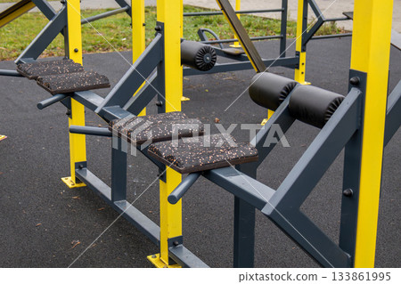 Colorful outdoor exercise equipment is set up in a city park, promoting fitness and healthy living within the community Colorful outdoor exercise equipment is set up in a city park, promoting fitness and healthy living within the community 133861995