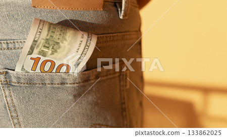 Few one hundred dollar banknotes in back pocket of men's jeans Few one hundred dollar banknotes in back pocket of men's jeans 133862025