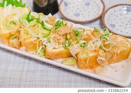 烤麵包上撒上蔥花和鰹魚片 烤麵包上撒上蔥花和鰹魚片 133862254