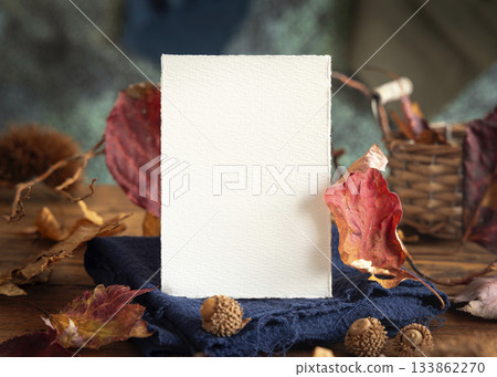Card on wood near autumn dried leaves closeup, wedding and party mockup in blue, red and orange Card on wood near autumn dried leaves closeup, wedding and party mockup in blue, red and orange 133862270