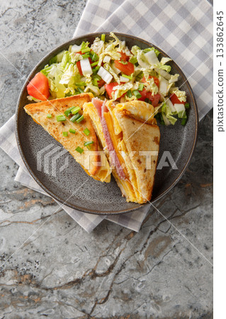 One Pan Breakfast Sandwich is the ultimate hack for busy mornings with egg, ham and cheese closeup on the plate . Vertical top view One Pan Breakfast Sandwich is the ultimate hack for busy mornings with egg, ham and cheese closeup on the plate . Vertical top view 133862645