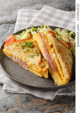 One-Pan Egg Sandwich with ham and cheese closeup on the plate. Vertical 133862652