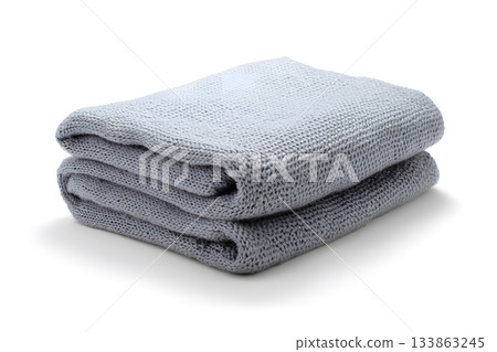 A gray knitted blanket is folded neatly on a white background. A gray knitted blanket is folded neatly on a white background. 133863245