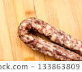 Sausage on a wooden board. 133863809