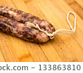 Sausage on a wooden board. 133863810