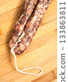 Sausage on a wooden board. 133863811