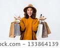 Woman smiles holding shopping bags and perfume bottles. 133864139
