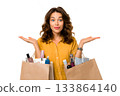 A woman shows shopping bags full of beauty products, presenting her purchases. 133864140