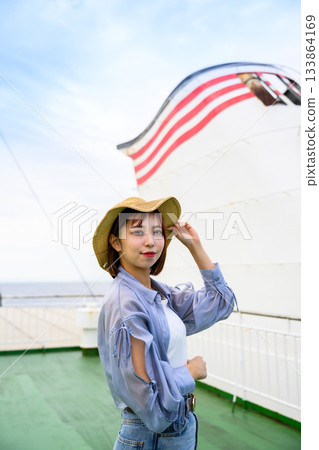 A young Japanese woman wearing a straw hat is enjoying a summer A young Japanese woman wearing a straw hat is enjoying a summer 133864169