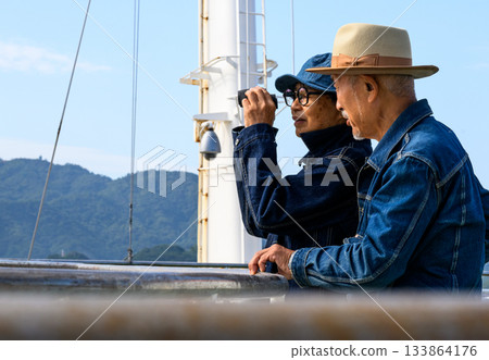 時髦的年輕女士們在船上用望遠鏡欣賞風景。 133864176