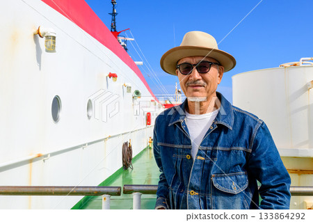 A Japanese man in his 50s appears to be relaxing on the ferry deck A Japanese man in his 50s appears to be relaxing on the ferry deck 133864292
