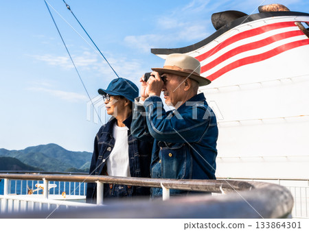 一對老年夫婦在渡輪上欣賞風景，船上的風扇也開著。 133864301