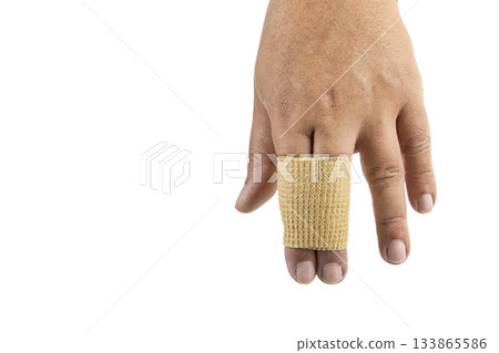 Close-up of a hand with a beige bandage wrapped around the index and middle fingers, shown on a white background, demonstrating Close-up of a hand with a beige bandage wrapped around the index and middle fingers, shown on a white background, demonstrating 133865586