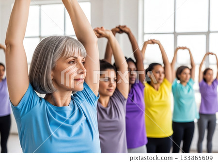 Group of diverse women stretching and exercising together in a fitness class for health and wellness 133865609
